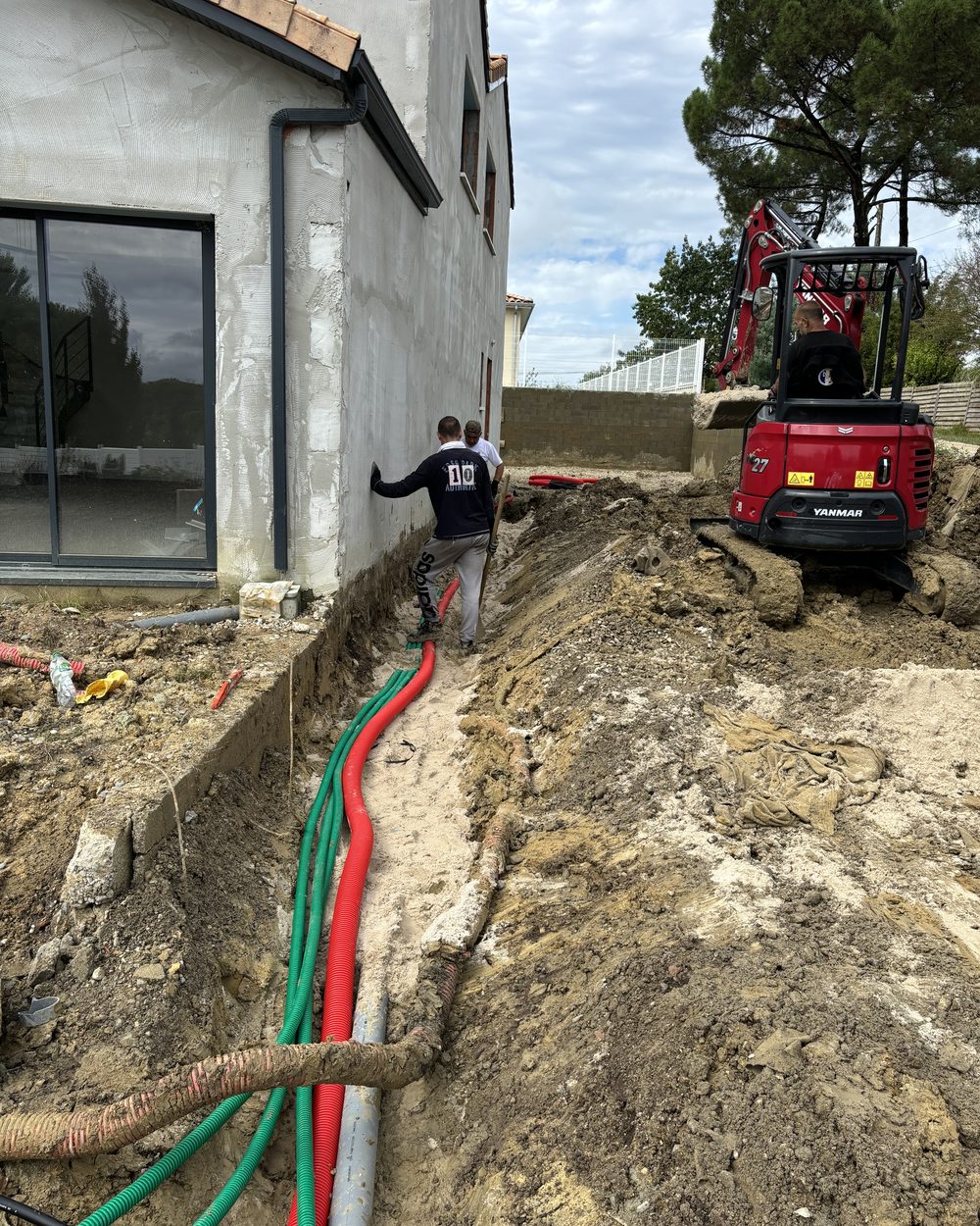 Tranchée de terrassement pour le passage des réseaux le long d'une maison